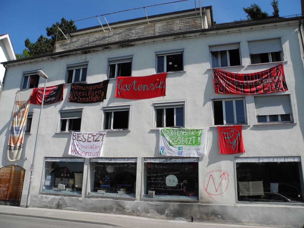 Das besetzte Haus Gartenstraße 7 in Tübingen mit Bannern mit Forderungen und Parolen, die aus dem Fenster hängen