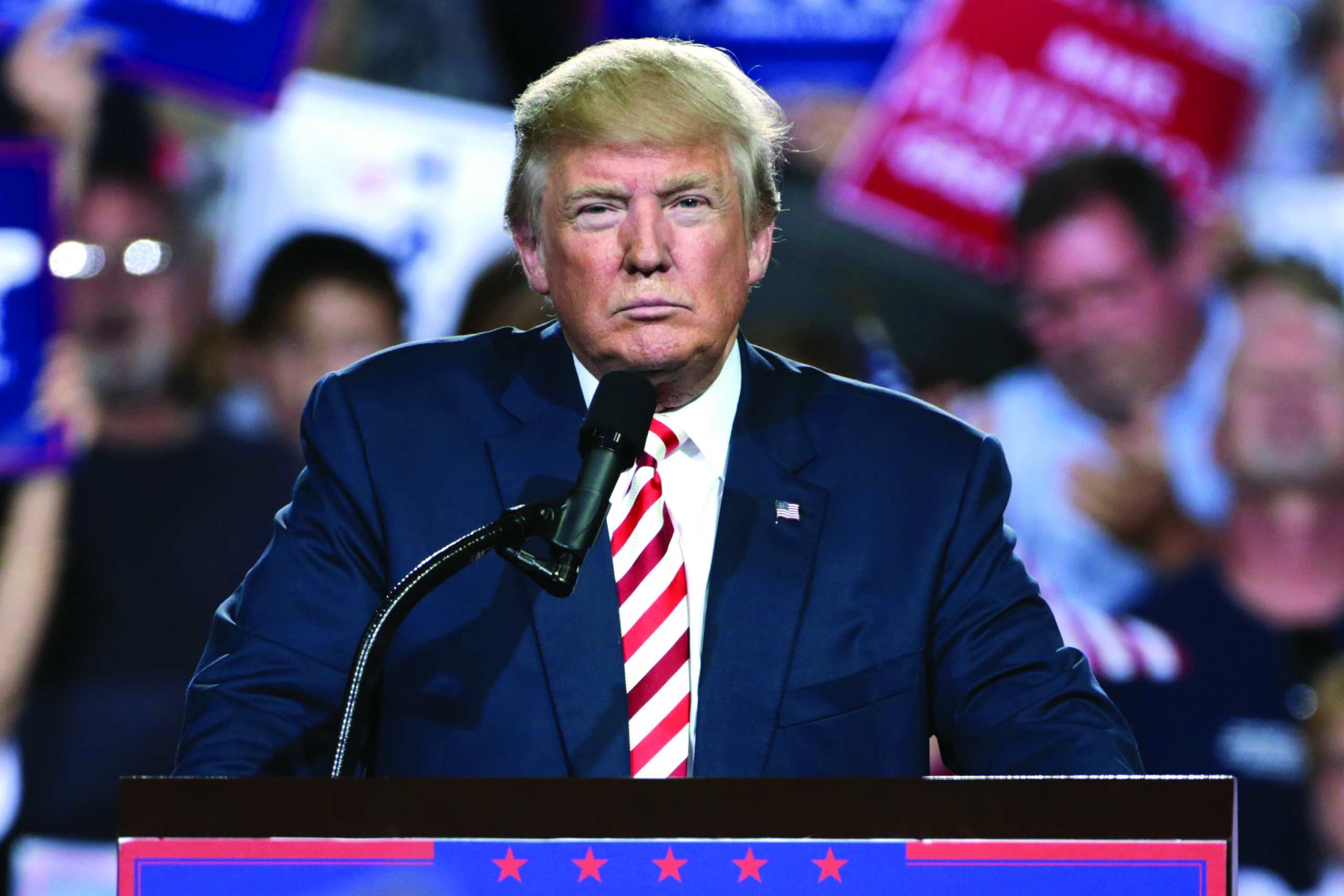 Donald Trump mit finsterer Miene vor einem Mikrofon